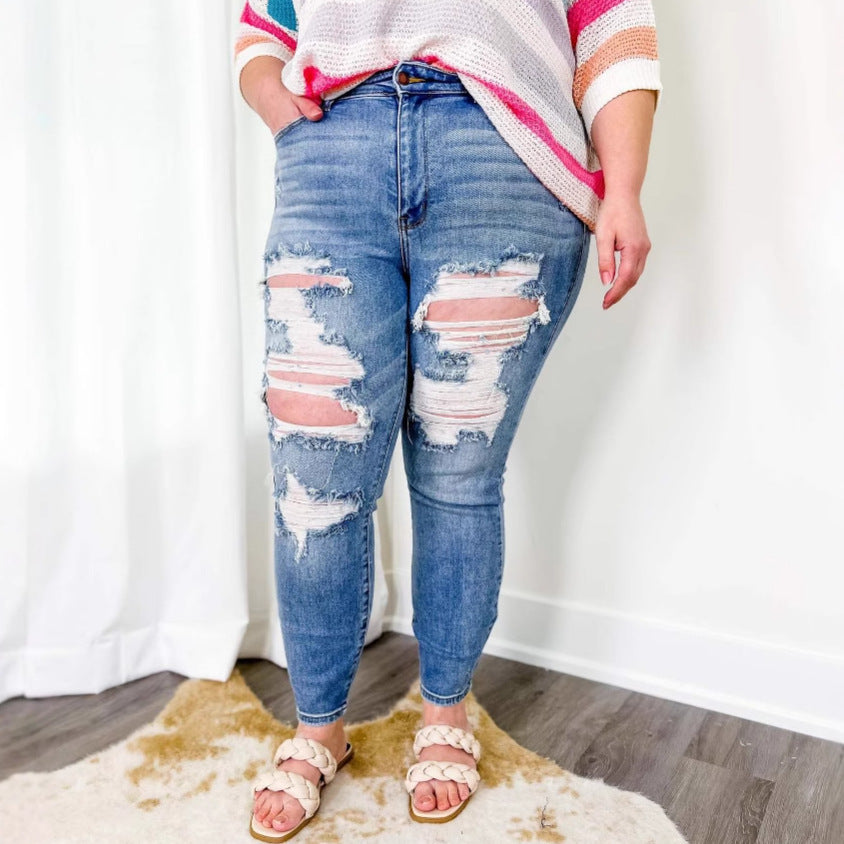 Jeans ajustados de lavado liviano angustiado con rasgaduras de rodilla extendidas